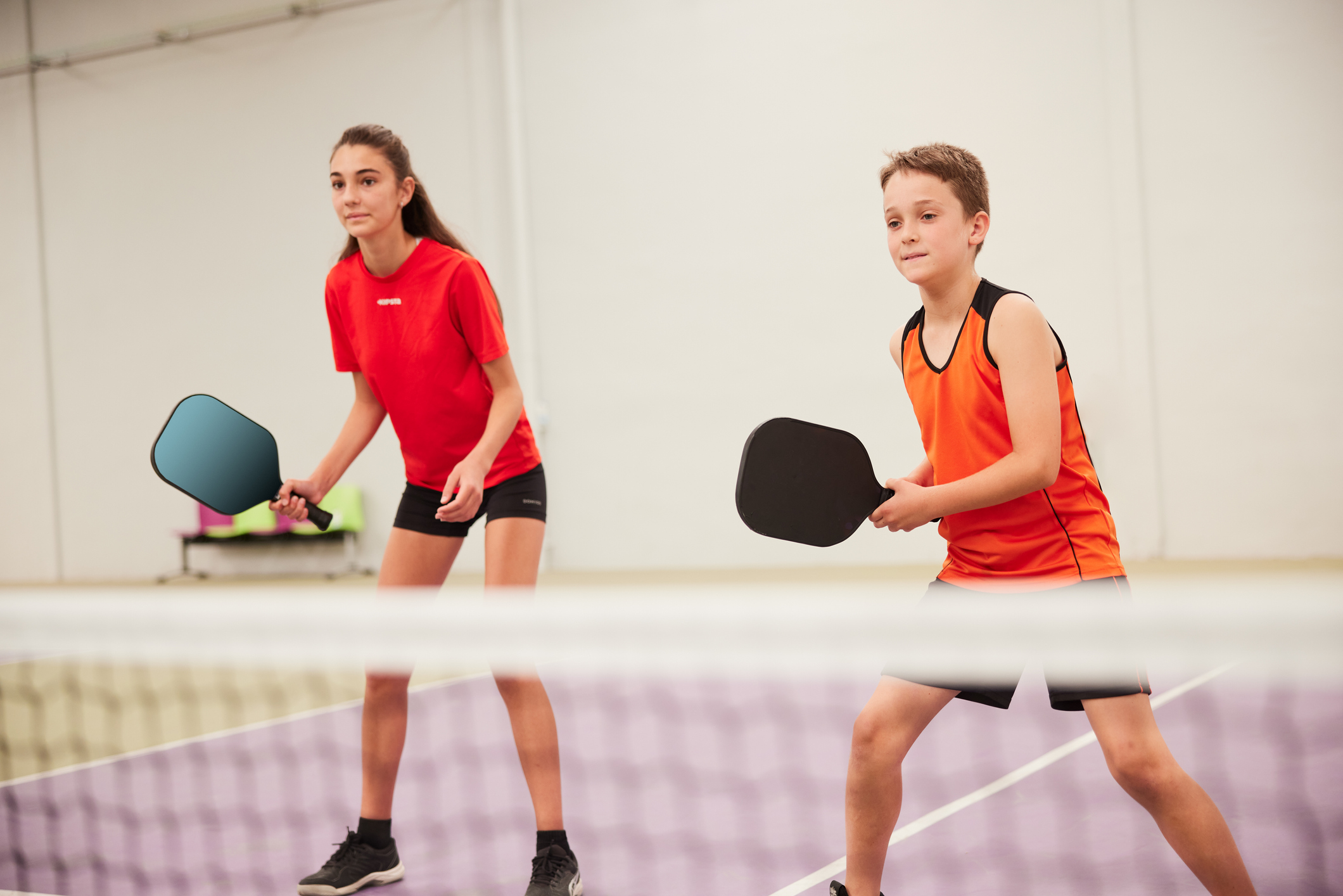 a boy and a girl playing pickleball