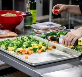 pouring sauce on sheet pan meal