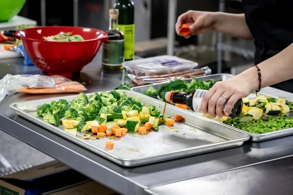 pouring sauce on sheet pan meal