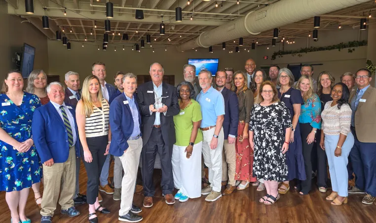 board and staff pose with eagle award